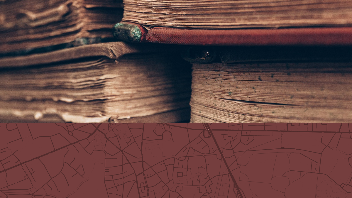 Gestapelte alte Bücher mit abgegriffenen Seiten, darunter eine abstrahierte Landkarte