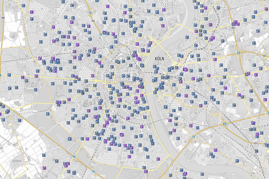Karte von Köln mit zahlreichen Symbolen für E-Ladestationen auf grauem Hintergrund