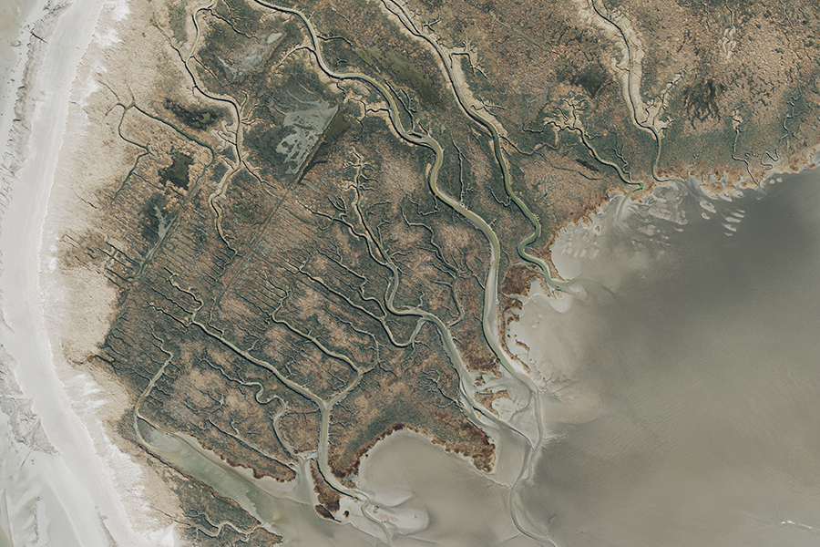 Luftbild einer Wattlandschaft mit Schlickflächen, Wasserläufen und Strukturmustern